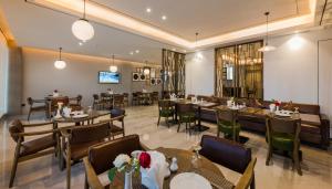 达曼Boudl Al Corniche的一间带桌椅的餐厅和一间用餐室