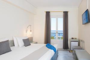 卡罗维西Samaina Port Hotel的卧室设有一张白色大床和一扇窗户。