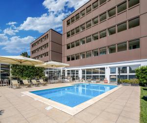 帕尔马法尔内塞加贝斯特韦斯特优质酒店的大楼前的游泳池