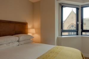 格拉斯哥格拉斯哥巴斯街高级公寓式酒店的一间卧室设有一张床和一个窗口