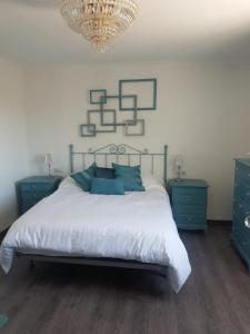 托罗克斯Casa Algill的一间卧室配有一张带蓝色家具和吊灯的床。