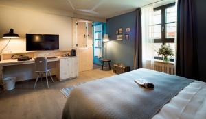 慕尼黑Marias Platzl的一间卧室配有一张床、一张书桌和一台电视