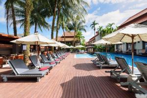 蔻立Khaolak Oriental Resort - Adult Only的游泳池旁的一排躺椅和遮阳伞