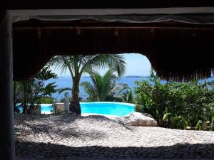 布桑加AL FARO Cosmio Hotel Palawan的遮阳伞下的游泳池景色