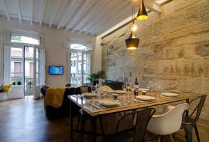 庞特维德拉Verdura Suites ArchSense Apartments的一间设有桌子和石墙的用餐室