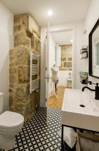 庞特维德拉Verdura Suites ArchSense Apartments的浴室设有石墙、卫生间和水槽。