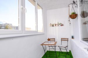 索非亚Atacama - spacious apartment in Lozenets area的一间设有两把椅子和一张桌子的房间,铺着绿色地毯