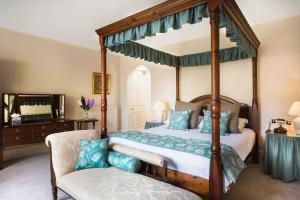 法尔茅斯潘莫瓦庄园酒店的一间卧室配有四柱天蓬床和椅子