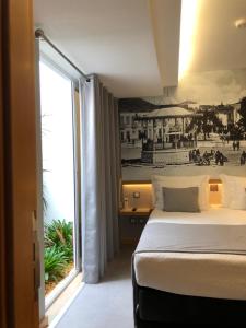 波尔蒂芒NDS Prestige Guest House and Suites - by Rocha Prestige的酒店客房设有一张床和一个大窗户