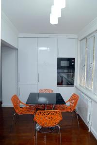 撒马尔罕Apartment on Registon Kochasi的一间用餐室,配有黑色桌子和橙色椅子