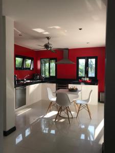 班泰野棕榈别墅的厨房设有红色的墙壁和桌椅