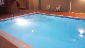 圣多明各Apart Hotel Turey的一个带椅子和桌子的大型蓝色游泳池