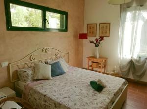 莫特拉下城区La Casetta的一间卧室,配有一张带绿色帽子的床