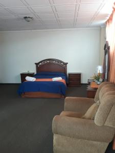 波托西图克斯拉皇家金堡旅馆的一间卧室配有一张床、一张沙发和一张床