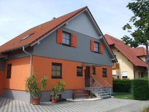 卡佩尔-格拉芬豪森Ferienwohnung Rheintal的橙色和灰色的房子,设有橙色的窗户