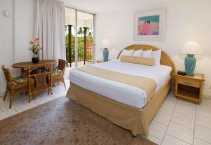 拉海纳雅诗顿毛伊卡阿纳帕利别墅酒店的一间卧室配有一张大床和一张桌子及椅子