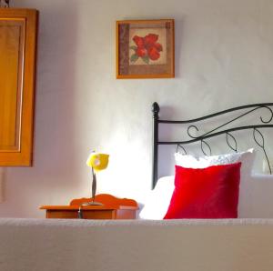 摩亚BELLA DORAMAS Casas Rurales Panchita & Millo的一间卧室配有一张带红色枕头和灯的床
