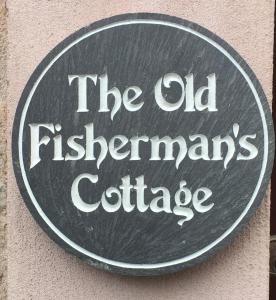 罗撒西Old Fisherman's Cottage的墙上的标志,上面写着老渔民小屋的字条