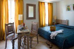 多尔多尼河畔博利厄Logis hotel les flots bleus的卧室配有1张床、1张桌子和1把椅子