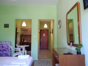 马克罗吉亚罗斯Rooms To Let Giannis的客房设有一张床和一个带镜子的厨房