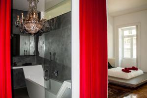 波尔图Amazing Riverside Balcony 2Br Apartment的一间带吊灯和红色窗帘的浴室