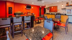 孟菲斯让X贝斯特韦斯特PLUS酒店的一间带桌椅和红色墙壁的餐厅