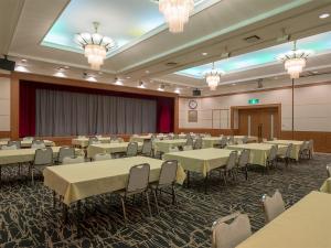 屋久岛THE HOTEL YAKUSHIMA ocean & forest的宴会厅配有桌椅和吊灯