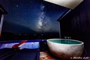 白滨XYZ私人Spa中心及海滨度假酒店 的浴缸位于享有宇宙景致的房间内