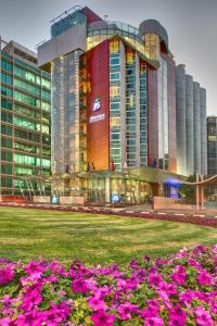 迪拜J5酒店 - 赛义德港的一座大建筑前面有粉红色的花朵