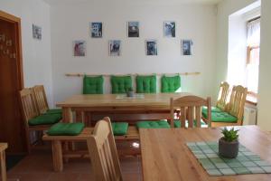 卢捷纳普德克利诺夫琴Vila Kokrhačka的一间带木桌和绿色靠垫的用餐室