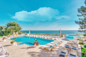 敖德萨Hotel Panorama De Luxe的一个带游泳池和椅子的度假胜地和大海