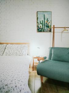 台南小北家二馆 -台南老屋包栋民宿的一间卧室配有一张床和一张沙发