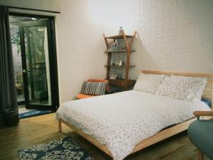 台南小北家二馆 -台南老屋包栋民宿的卧室配有床、椅子和窗户。