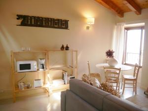 利莫内-苏尔加达Appartamenti Ca' nei Vicoli的带沙发和微波炉的客厅