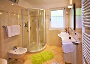 奥蒂塞伊Apartment Larjëi的带淋浴、盥洗盆和卫生间的浴室