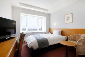 雾岛市京瓷酒店的配有一张床和一台平面电视的酒店客房