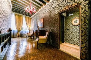 威尼斯埃尔凯鲁比尼旅馆的一间设有椅子和墙上时钟的房间