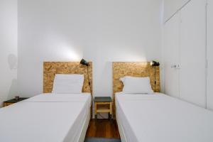 里斯本马德拉果阿舒适公寓的白色墙壁客房的两张床