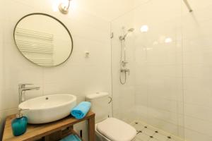 华沙Rental Apartments Wilcza的一间带水槽、卫生间和镜子的浴室