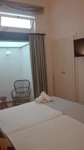 塞维利亚皮拉德尔帕多卡萨精品旅馆的卧室配有一张大白色床和窗户