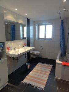 米伦申比尔小木屋酒店的浴室配有盥洗盆、卫生间和浴缸。