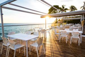 拉利伯塔德Acantilados的一间在甲板上配有白色桌椅的餐厅