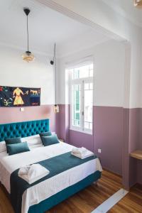 雅典Neratzia Rooms的一间卧室设有一张大床,拥有紫色和紫色的墙壁