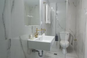 雅典Neratzia Rooms的白色的浴室设有水槽和卫生间。