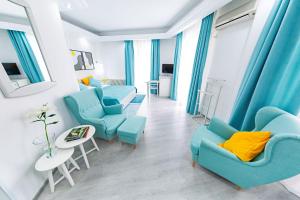布加勒斯特放松舒适套房酒店的客厅配有蓝色的椅子和桌子