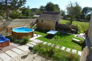Bény-sur-Mer小堡度假屋的一个带游泳池和房子的小后院