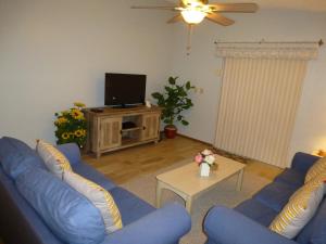 基西米The Florida Pad的客厅配有蓝色的沙发和电视