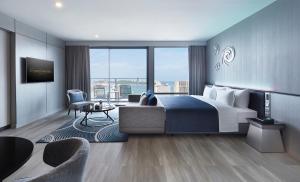 芭堤雅市中心芭提雅格兰德中心大酒店的一间带大床的卧室和一间客厅