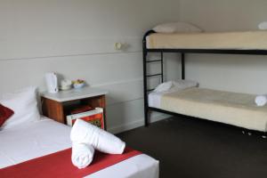 楠伯南博海滨汽车旅馆的客房设有两张双层床和一张带毛巾的床。