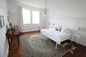 阿尔弗雷德港Cumberland House的一间卧室配有一张天蓬床和地毯。